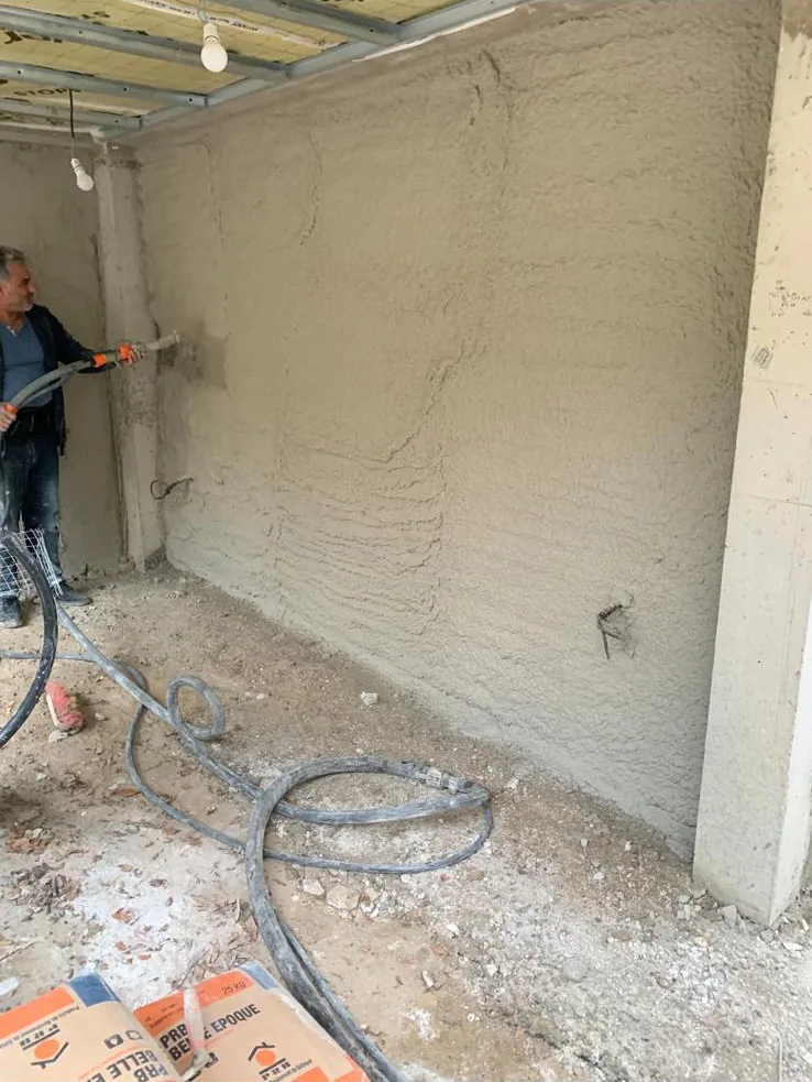 Mur en pierre après enduit projeté